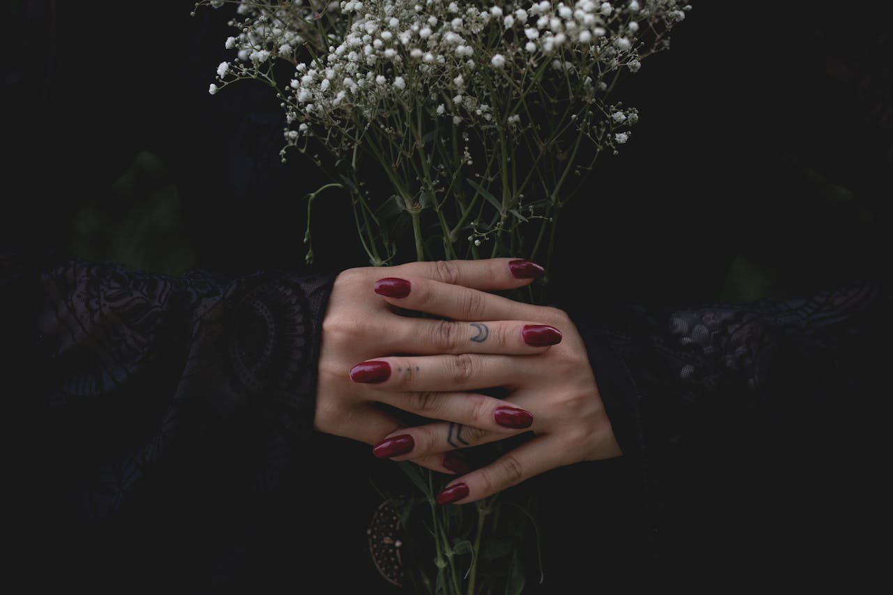 our-services-3 Elegant hands with red nails holding a bouquet of white gypsophila, evoking a mystical and serene vibe.